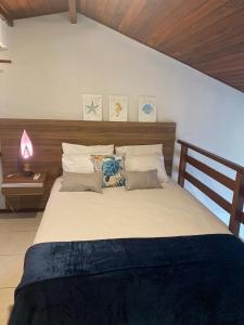 a bedroom with a large bed with pillows at Duplex no Centrinho de Pipa cozinha e 2 banheiros in Pipa