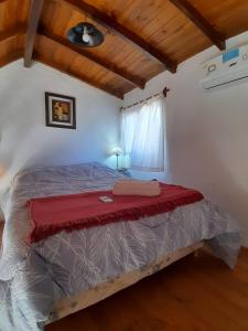 a bedroom with a bed with a red blanket on it at Cabañas de Panaholma in Panaholma