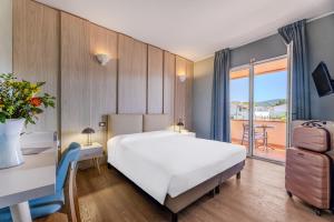 a bedroom with a large white bed and a balcony at Hotel Riva del Sole in Marina di Campo +58 photos