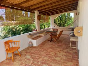un patio con sedie, tavolo e 2 finestre di Vila Kuka 2 a Tavira