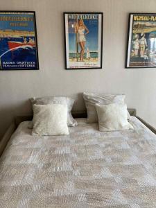 a bed with two posters on the wall and two pillows at Studio West-Ende in Middelkerke
