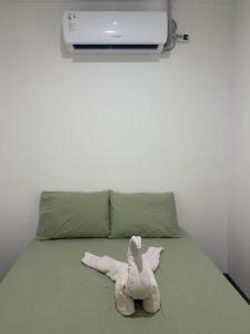 a stuffed animal is laying on a bed at Apartamento KERU in San Juan del Sur