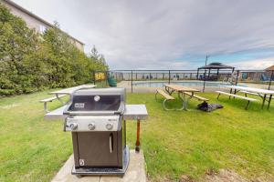 a barbecue grill and picnic tables in a park at The Driftwood Deck 5B in Wasaga Beach