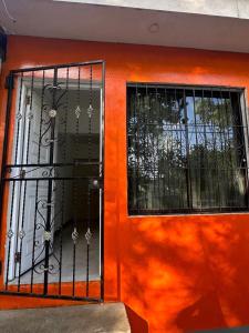 a front door of a house with an orange wall at Apartamento KERU in San Juan del Sur