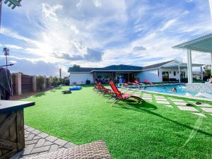 a yard with lawn chairs and a swimming pool at The Phoenix Farmhouse in Phoenix
