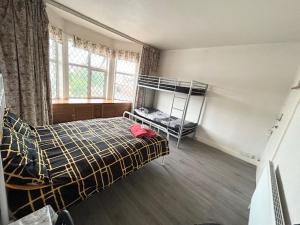 a bedroom with a bed and bunk beds in it at Double Bedroom Near Heathrow Airport & London in Hayes