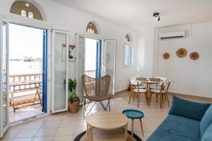 a living room with a blue couch and a table at Casa Chora by Sea ALure in Tinos