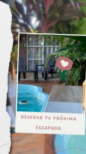 a picture of a pool with a sign for a resort tu programme escapa at Ámbar house apart Iguazú in Puerto Iguazú