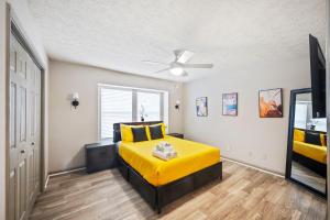 1 dormitorio con cama amarilla y ventilador de techo en King Bed 5 min walk Truist Park The Battery, en Atlanta