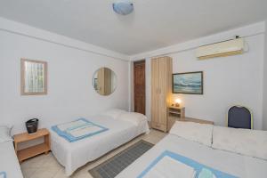 a white bedroom with a bed and a couch at Mijailovic apartmani PARKING WI FI AIR CONDITION FREE in Kaluđerac