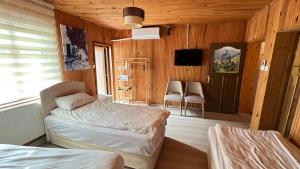a bedroom with two beds and a tv in it at Lavera Home Uzungöl in Uzungöl