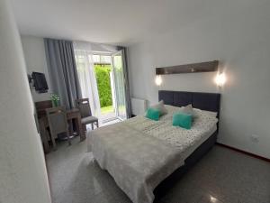 a bedroom with a large bed with green pillows at Villa Over Lake in Mielno