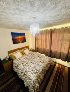 AshにあるSurrey Hills Retreat - 2-Bed - Easy London Accessのベッドとシャンデリアのある寝室 +7枚の写真