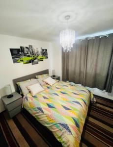 AshにあるSurrey Hills Retreat - 2-Bed - Easy London Accessのベッドルーム1室(カラフルなベッド1台、シャンデリア付)