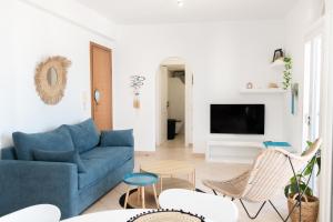 a living room with a blue couch and chairs at Casa Chora by Sea ALure in Tinos