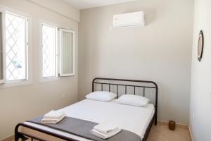 a bedroom with a bed with two towels on it at Casa Chora by Sea ALure in Tinos