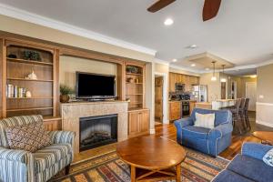 a living room with a fireplace and a tv at CSC2R - Dolphins Den in Kill Devil Hills
