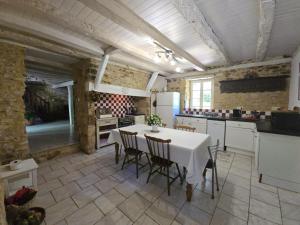 a kitchen with a table and chairs in a room at Gîte de charme en Dordogne avec piscine et jardin - FR-1-616-485 in Berbiguières