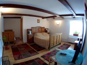 a bedroom with a bed and a table and a window at Casa Gross in Cristian