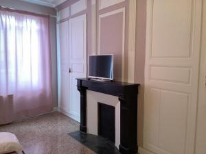 a tv sitting on top of a fireplace in a room at Le Rameau in Sainte-Menehould