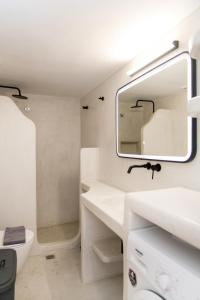 a white bathroom with a sink and a mirror at Casa Chora by Sea ALure in Tinos +40 photos