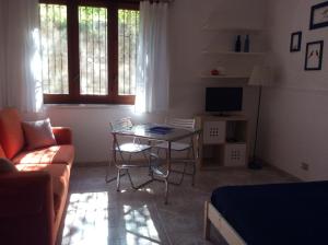 ein Wohnzimmer mit einem Sofa und einem Tisch in der Unterkunft Appartamento Gardenhouse in Acitrezza
