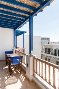 a balcony with a blue pergola and a table at Casa Chora by Sea ALure in Tinos