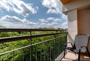 a chair on a balcony with a view at Stablewskiego Poznań Spot in Poznań