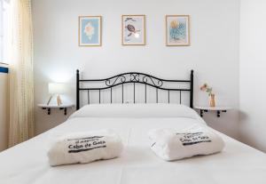 a bedroom with a white bed with two towels on it at Casa Dracaena in San José