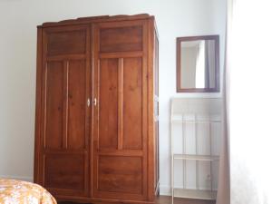 a wooden cabinet in a room with a mirror at Buxerioux Retreat in Châteauroux +10 photos