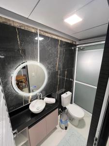 ein Badezimmer mit Waschbecken, Spiegel und Toilette in der Unterkunft Condomínio Alto da Serra Negra in Bezerros