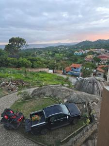 ein schwarzes Auto mit einem Motorrad auf einem Felsen geparkt in der Unterkunft Condomínio Alto da Serra Negra in Bezerros