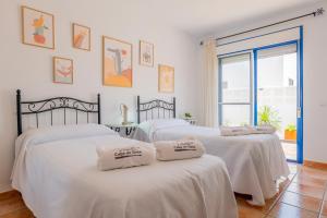 three white beds in a room with a window at Casa Dracaena in San José