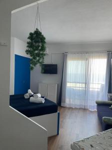 Una sala de estar con una cama azul y una ventana. en Piera's Paraiso Seaview, en Playa Paraiso