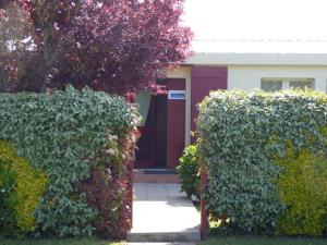 une maison avec deux haies devant une porte dans l'établissement Appartemet en rez de jardin Au Clos du Golfe, à Locmariaquer 2 autres photos