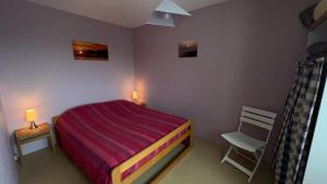 une petite chambre avec un lit et une chaise dans l'établissement Appartemet en rez de jardin Au Clos du Golfe, à Locmariaquer