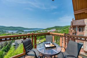 a balcony with a table and chairs and a view at Tremblant Prestige - Altitude 170-9 in Mont-Tremblant +20 photos