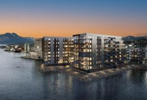 a large building on the water next to a city at Wonderful apartment in centrum in Tromsø