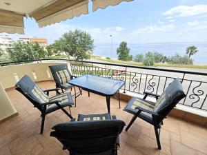 a patio with chairs and a table on a balcony at Endless blue apartment kassandra in Nea Fokea
