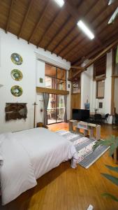 a bedroom with a large bed and a living room at Casa ROMERO EN FLOR in Medellín +25 photos