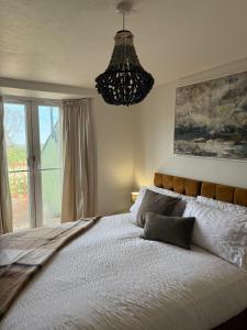 a bedroom with a large bed with a chandelier at St Davids Art House in St. Davids +20 photos