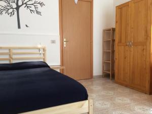 Schlafzimmer mit einem Bett und einer Holztür in der Unterkunft Appartamento Gardenhouse in Acitrezza