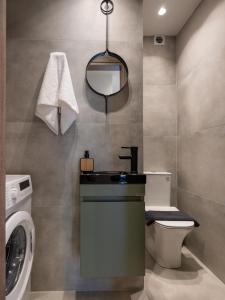 a bathroom with a sink and a washing machine at Ergina Apartments Gournes Studio & Family Apartment in Gournes