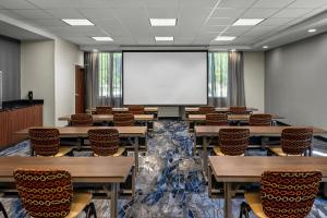 ミッドベールにあるFairfield Inn & Suites by Marriott Salt Lake City Midvaleのテーブルと椅子、プロジェクションスクリーン付きの教室