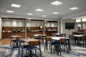 ミッドベールにあるFairfield Inn & Suites by Marriott Salt Lake City Midvaleのテーブルと椅子とテレビのあるダイニングルーム