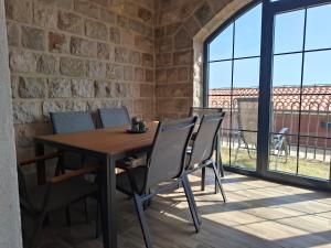 a wooden table and chairs in a room with a window at Tamape apartment in Katun