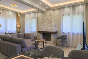 Una sala de estar con un sofá y una chimenea. en Rea Villa, Vourvourou, en Diaporos