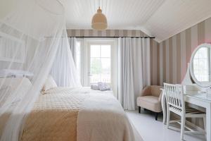 een slaapkamer met een bed, een bureau en een stoel bij Villa Ankkuri in Hanko