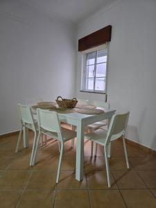 a white table and chairs in a room at Casa Alfazema in Faro