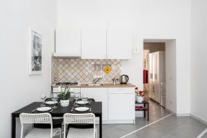 维克艾库塞Marisabella luxury home的厨房配有白色橱柜和黑色桌椅
